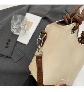 Détails d'un sac seau minimaliste montrant la ferronnerie argentée et le gaufrage