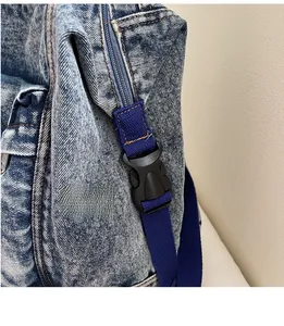 Close-up of durable resin buckle and nylon strap on washed blue denim backpack detail