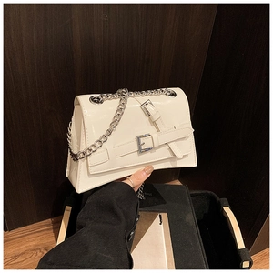 Detail of white leather crossbody bag with silver chain strap and buckle closure