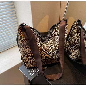 Detail of large leopard print tote bag with wide brown strap and soft canvas texture