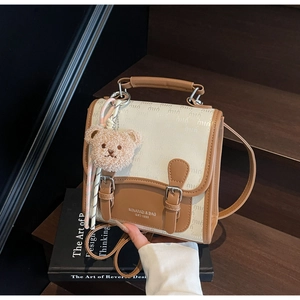 Détail du sac à dos rétro britannique en toile beige avec finitions en cuir marron