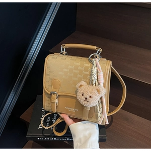 Vue détaillée d'un sac à dos vintage imperméable avec un porte-clé ours en peluche