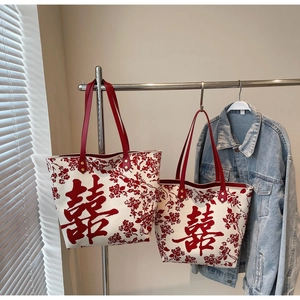 Detail of cream canvas tote bag set with red floral patterns and Chinese double joy symbol