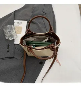 Vue intérieure du sac seau crème montrant un rangement spacieux et une poche zippée