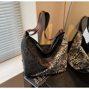 Detail of mixed leopard print canvas tote bag featuring durable wide nylon shoulder strap