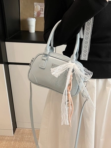 Elegante hellblaue Lackleder-Kissentasche mit Spitzenschleife in Lifestyle-Ansicht gezeigt