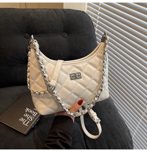 Detail der weißen gesteppten Halbmond-Tasche mit silberner Kette und Drehverschluss