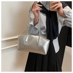 Detail of a silver metallic tote bag with thin straps and side knot decorative elements