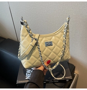 Detailansicht der beigen gesteppten Hobo-Tasche mit Silberkette und Metallverschluss