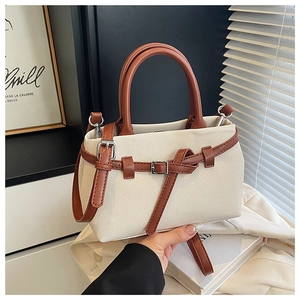 Detail of canvas bucket bag with brown leather trim on a vintage minimalist desk