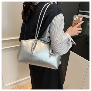 Close-up of metallic silver tote bag with textured faux leather and knotted strap detail