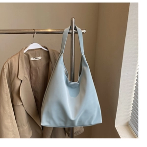 Detail view of the soft light blue large capacity tote bag hanging on a rack