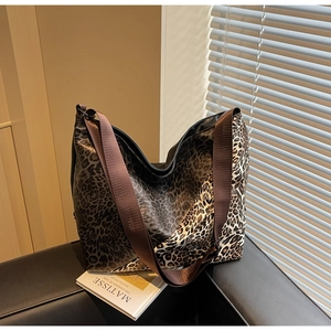 Close-up of leopard print tote bag with glossy texture and wide nylon shoulder strap