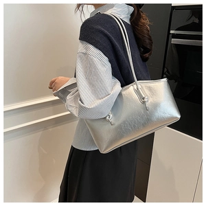 Macro shot of silver metallic tote bag featuring fine leather texture and sleek straps