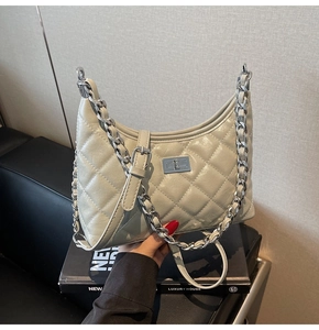 Nahaufnahme der beigen gesteppten Ledertasche mit silberner Kette und Metallverschluss