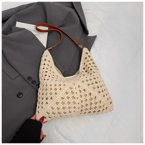 Détail d'un sac en tricot crème avec maille évidée et bandoulière en cuir marron