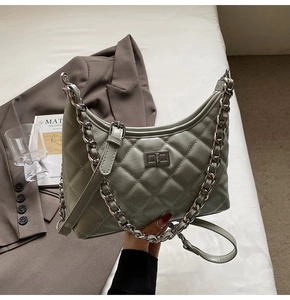 Detail der salbeigrünen gesteppten Tasche mit Silberkette und Metall-Drehverschluss