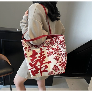 Detail of red floral knit tote bag with double handles and traditional Xi character