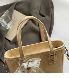 Détails du sac crème plissé avec poignées robustes et nœud en dentelle aux perles