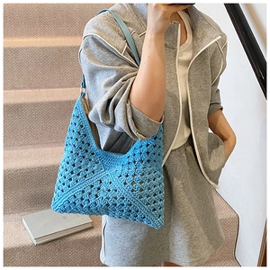 Detail of blue crochet tote bag with hollow knit pattern and light blue leather strap