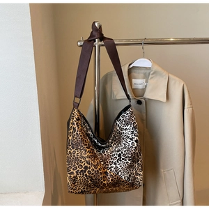 Detail of leopard print patchwork hobo bag with wide shoulder strap and knot design