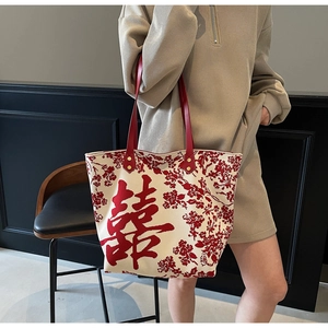 Detail of red leather handles and gold rivet reinforcement on canvas wedding tote bag