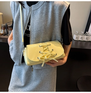 Detail of lemon yellow crossbody bag featuring stylish lace-up design and bow knot detail