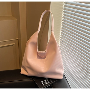 Pink crescent tote bag detail with smooth leather finish in a soft natural light setting