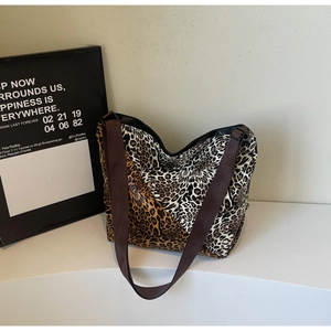 Detail of multi-textured leopard print tote bag with a wide dark brown fabric strap