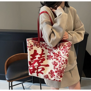 Detailed side view of a large wedding tote bag with red Xi characters and floral patterns