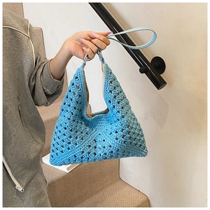 Gros plan sur le sac hobo en crochet bleu ciel avec texture tricotée et bandoulière cuir