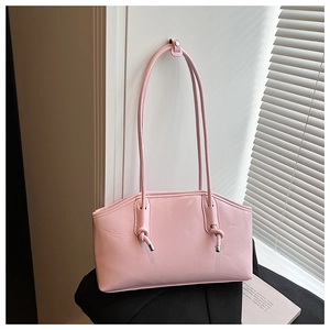 Close-up of pink glossy patent leather tote bag with unique knotted long strap details