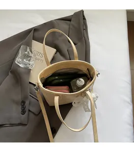 Vue de dessus du sac seau beige montrant l'espace intérieur avec téléphone et portefeuille