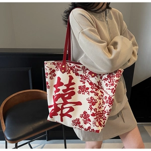 Detail of canvas tote bag with red Double Happiness character and floral pattern embroidery