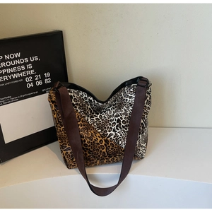 Close-up of leopard print tote bag featuring mixed patterns and wide brown shoulder strap