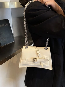 Chic off-white patent leather crossbody bag with silver chain strap and buckle detail