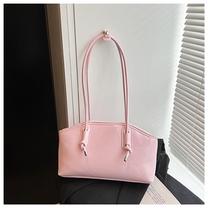 Detail of light pink glossy leather tote bag with elegant knot strap and trapezoid shape
