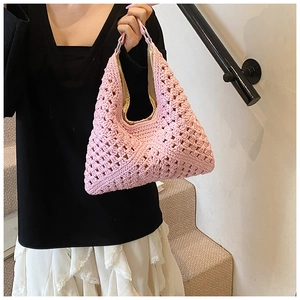Vue détaillée du sac cabas en tricot rose avec poignée en cuir et boucles en métal