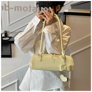 Close-up of cream leather shoulder bag with a large bow detail and heart pendant