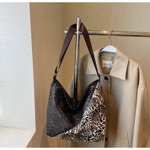 Detail of hobo bag featuring leopard print patchwork and wide fabric shoulder strap