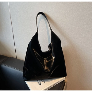 Glossy black patent leather tote bag detail showing large capacity and shiny finish