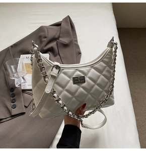 Detailansicht der weißen Stepptasche in Halbmondform mit Silberkette und Drehverschluss