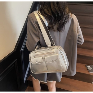 Detail of silver metallic tote bag with front flap pockets and glossy PU leather texture