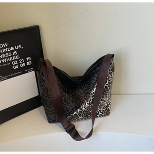 Macro detail of patchwork leopard print tote bag with adjustable wide fabric strap