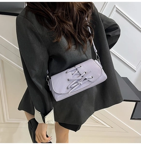Lavender purple shoulder bag with criss-cross decorative straps and fine leather texture