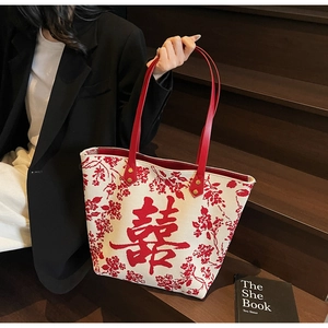 Detail of white tote bag with red floral patterns and Chinese double happiness character