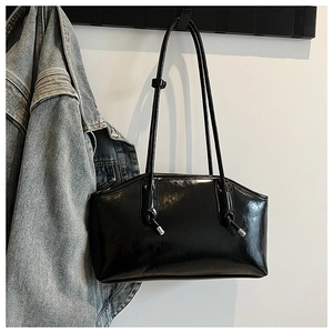 Detail of a glossy black underarm bag with unique drawstring silver hardware and handle