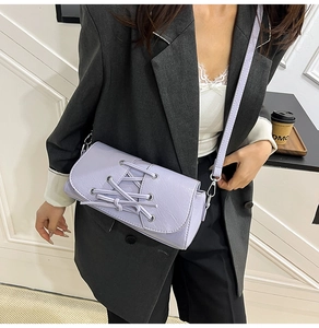 Close-up of a light purple crossbody bag featuring trendy corset-style lace-up detailing