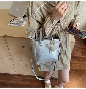 Sac fourre-tout argenté métallisé à texture plissée avec breloque perle sur un mannequin
