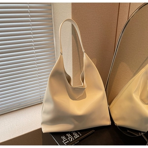 Minimalist cream white leather tote bag shown in a cozy aesthetic lifestyle setting
